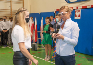 Dyrektorka wręcza legitymację uczniowi podczas ślubowania