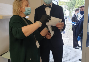 Nauczyciel objasnia uczniowi paski kodowe na egzamin maturalny