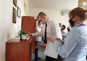 Uczeń podpisje listę odbioru arkuszy