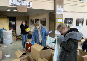 Uczniowie przenoszą paczki z darami uzbieranymi przez wolontariuszy