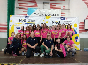 Uczennice w różowych koszulkach pozują do zdjęcia z czołowymi lekkoatletkami:Joanną Fiodorow oraz Małgorzatą Hołub-Kowalik